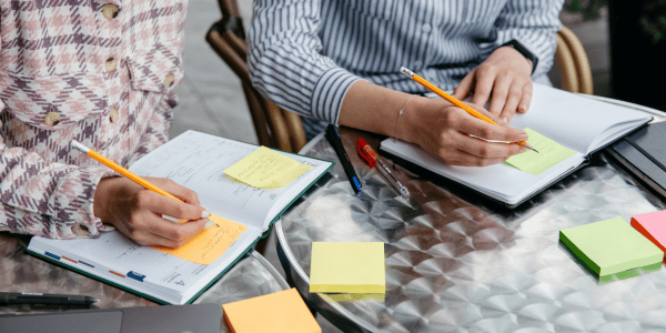 People writing with sticky notes